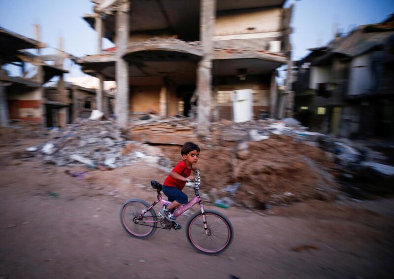 A bicycle ride near the rubble of a house in Gaza that was destroyed during the Israeli-Palestinian conflict. Reuters