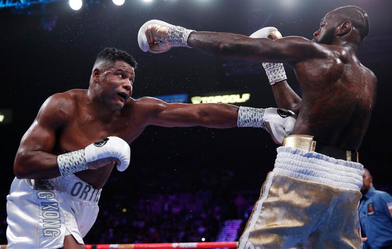 Luis Ortiz hits Deontay Wilder during their WBC heavyweight title fight in Las Vegas.AP