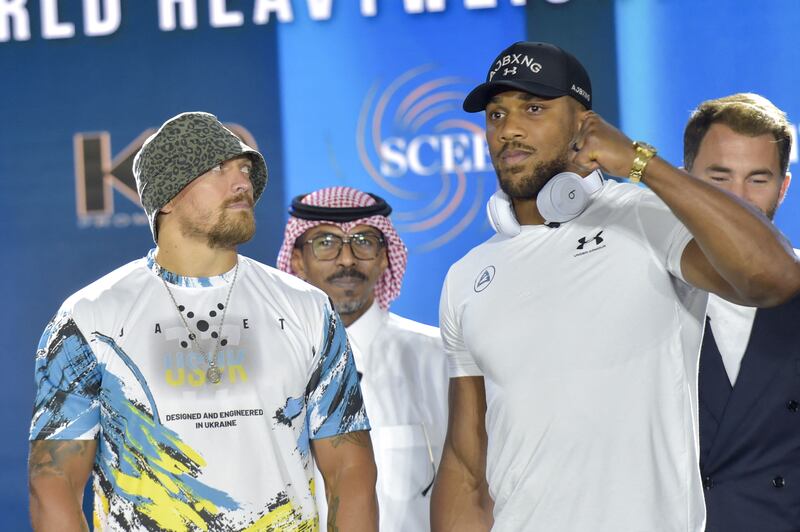 Ukraine's Oleksandr Usyk (L) and Britain's Anthony Joshua (R) pose for a picture during the press conference to announce the heavyweight boxing rematch for the WBA, WBO, IBO and IBF titles in Jeddah on June 21, 2022.  - The match, billed as Rage on the Red Sea, is set to take place on August 20, 2022, at the Jeddah Super Dome.  (Photo by Amer HILABI  /  AFP)