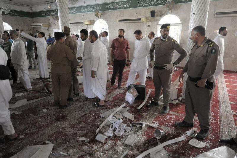 A saudi policemen gathers around debris. Onee witness described a huge explosion at the Imam Ali mosque in the village of Al Qadeeh. AFP Photo