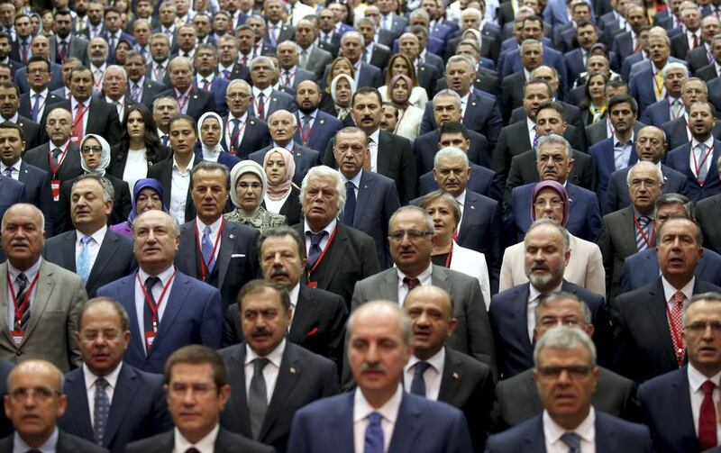 Among other members of the ruling Justice and Development Party, or AKP, Turkey’s President Recep Tayyip Erdogan, centre, with Turkey’s Prime Minister Binali Yildirim, participate in a ceremony to mark Erdogan rejoining the party in Ankara, Turkey. AP Photo