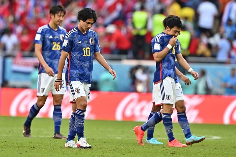 Takumi Minamino, second left, of Japan reacts after the match. EPA