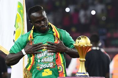 Senegal's forward Sadio Mane looks at the trophy prior to the ceremony after winning after the Africa Cup of Nations (CAN) 2021 final football match between Senegal and Egypt at Stade d'Olembe in Yaounde on February 6, 2022. (Photo by CHARLY TRIBALLEAU / AFP)