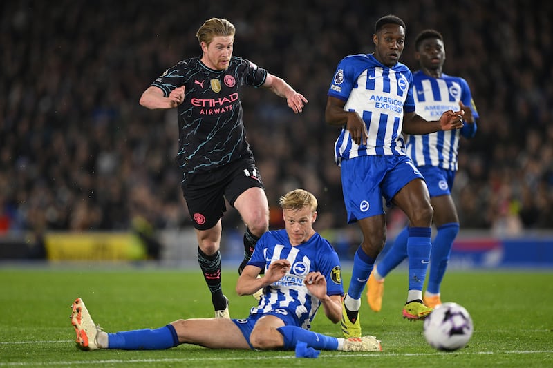 Kevin de Bruyne of Manchester City is challenged by Jan Paul van Hecke of Brighton during the Premier League match at Amex Stadium on April 25, 2024 in Brighton, England. Man City won the match 4-0 to move up to second in the table. Getty