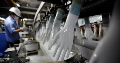 FILE PHOTO: A worker inspects newly-made gloves at Top Glove factory in Klang outside Kuala Lumpur January 13, 2009. REUTERS/Bazuki Muhammad/File Photo