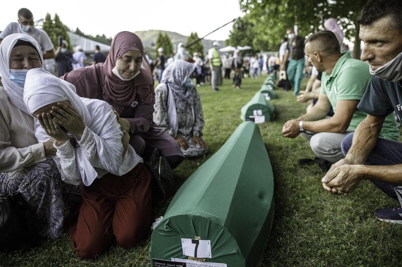 Bosnian Muslims cry over a coffin with the remains of a relative killed at Srebrenica in July 1995. Getty Images