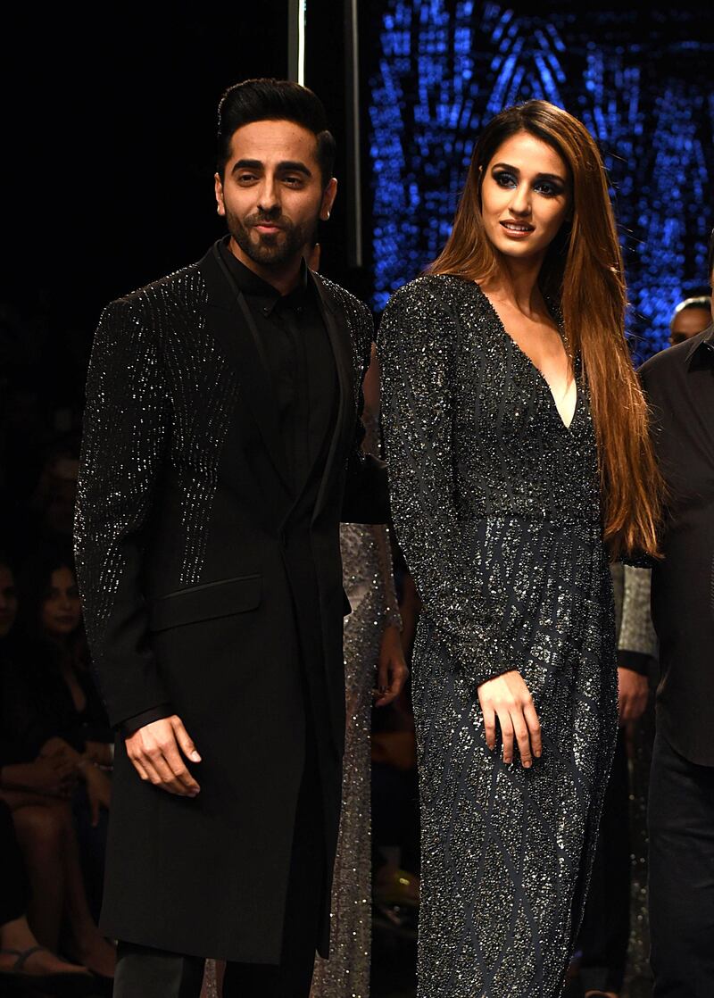 Indian Bollywood actors Ayushmann Khurrana (L) and Disha Patani (R) present creations by the designer brand Rohit Gandhi and Rahul Khanna at Lakmé Fashion Week (LFW) Winter Festive 2019 in Mumbai on August 24, 2019.  / AFP / Sujit Jaiswal
