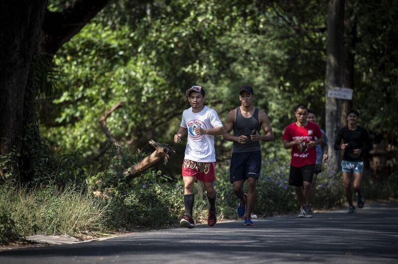 World Boxing Council (WBC) mini-flyweight champion, Wanheng Menayothin, running with other boxers from his gym before a training session in Bangkok. Lillian Suwanrumpha / AFP