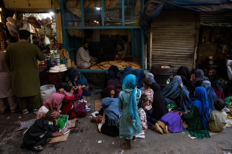 Afghan women and children wait at a bakery for bread donations in Kabul's Old City, Afghanistan, on September 16. AP