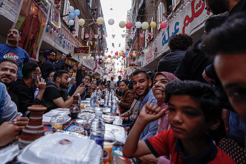 Egyptian Muslims gather in streets lined with long tables to break their Ramadan fast together in a mass iftar meal in Cairo's Matareya suburb. All photos: AFP