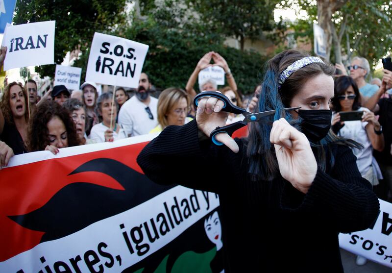 A woman cuts her hair during the protest in front of the Iranian embassy in Madrid. Reuters