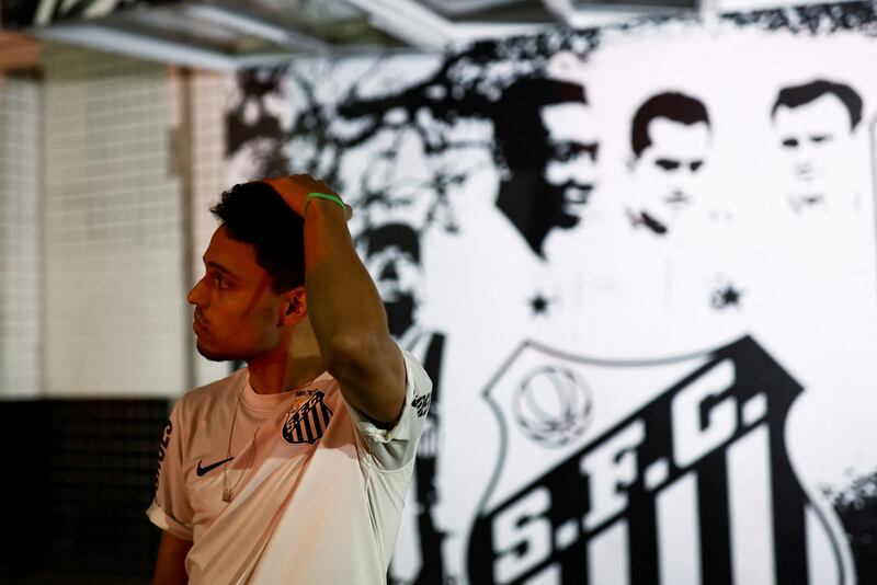 A fan reacts as he mourns the death of Brazilian football legend Pele in Santos, Brazil. Reuters