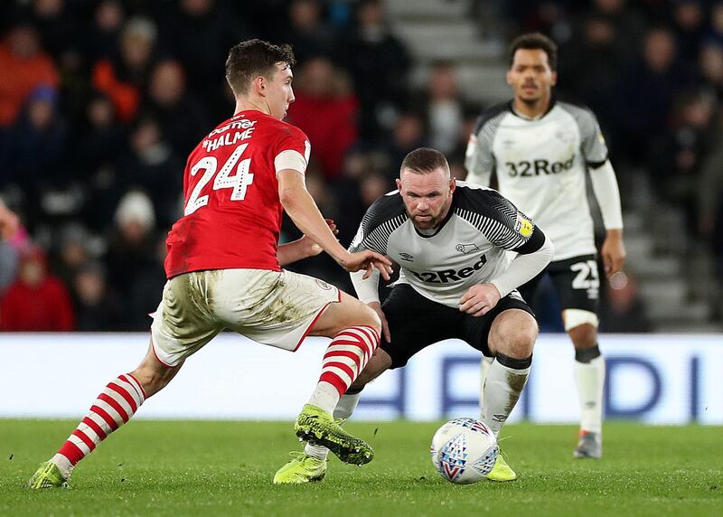 Barnsley's Aapo Halme, left, in possession with and Wayne Rooney keeping a close eye. PA
