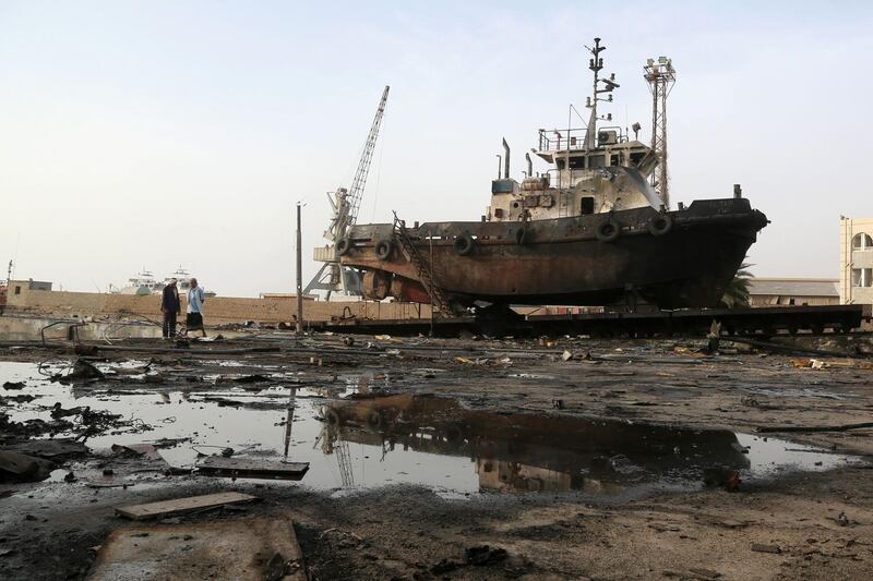 (FILES) In this file photo taken on May 27, 2018 Workers inspect damages at the site of an air strike on the maintenance hub at the Hodeidah port. Four years after Saudi Arabia led a military intervention in Yemen to back the government against rebels, the only hope for peace in a country threatened by famine hangs on a fragile truce.
 / AFP / ABDO HYDER
