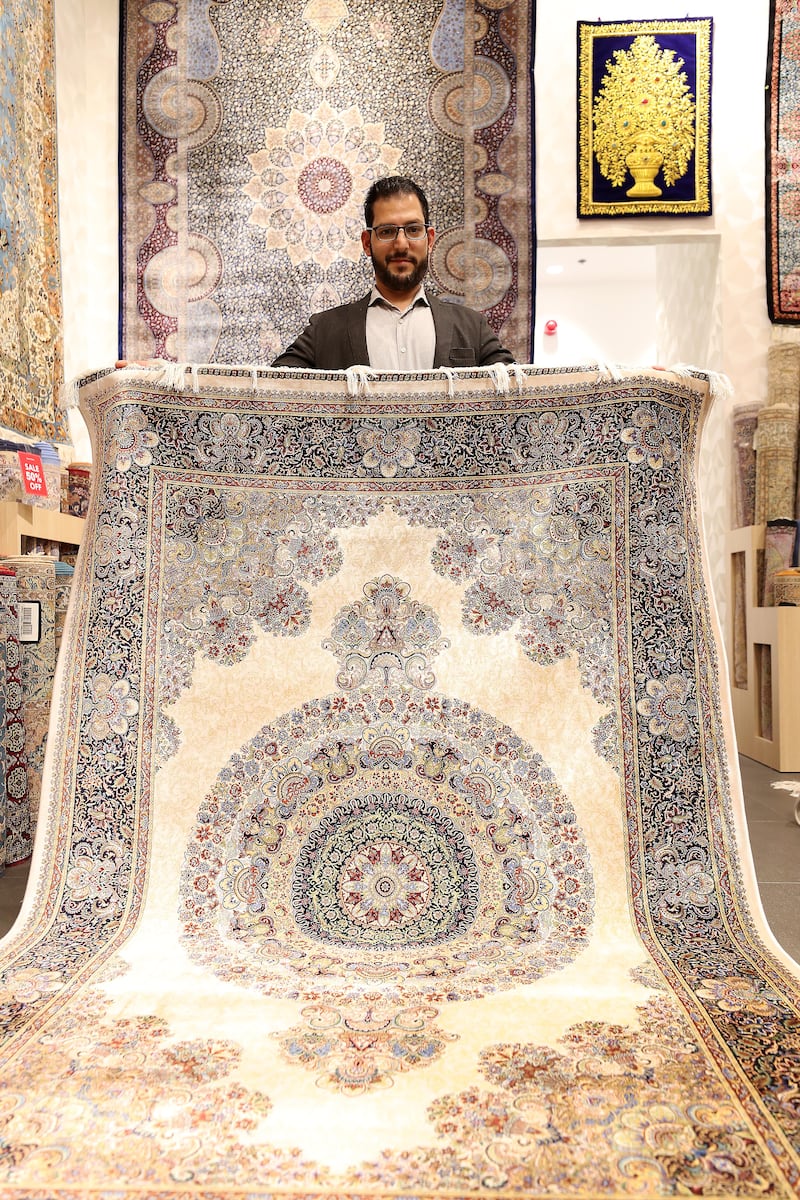 Irfan Jan, a sales executive at Kani Home, with a Persian carpet.