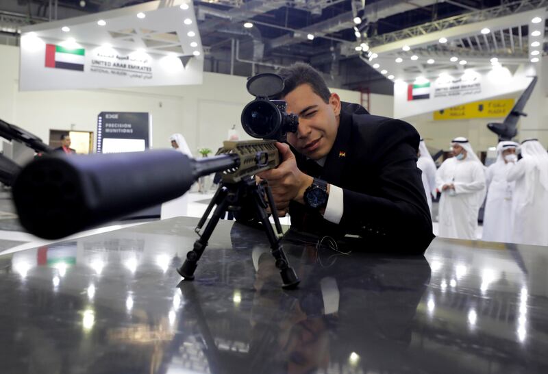 A visitor to the UAE stand checks a weapon at Edex, the Egypt Defence Expo, in Cairo. About 300 exhibitors are showing off the latest defence technology, equipment and systems across land, air and sea. Reuters