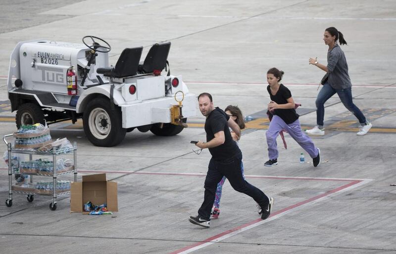 People run on the tarmac at Fort Lauderdale’s Hollywood International Airport after a gunman opened fire in a baggage claim area on January 6, 2017. Wilfredo Lee / AP Photo
