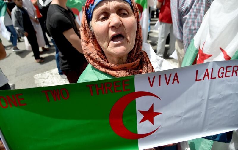 An old woman holds the national flag during a demonstration in Algiers, Algeria. AFP