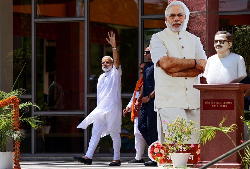 Indian Prime Minister Narendra Modi waves to supporters at the Trade Facilitation Centre and Crafts Museum after offering prayers at the famous Kashi Vishwanath temple, in Varanasi on May 27, 2019. Thousands of jubilant supporters cheered Prime Minister Narendra Modi on May 27 as he set about a victory rally in the Hindu holy city to Varanasi after sweeping the general elections. / AFP / SANJAY KANOJIA
