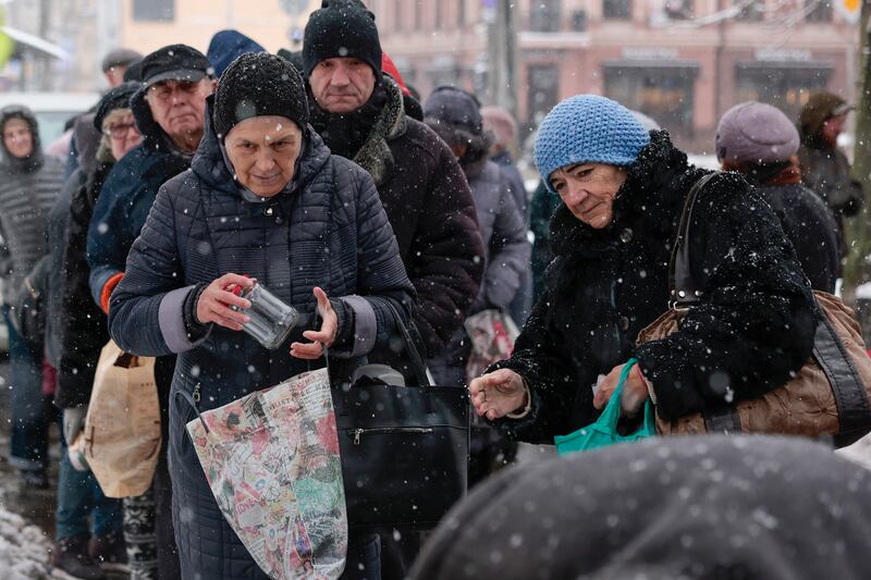 Elderly Ukrainians queue for food and gloves from a charity in Kyiv in the snow. Getty