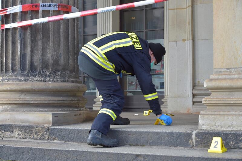 A policeman checks for evidence outside the Royal Palace. Reuters