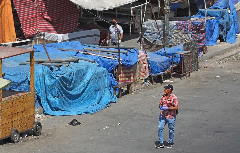 Men walk by covered stalls in the Iraqi capital Baghdad.  AFP