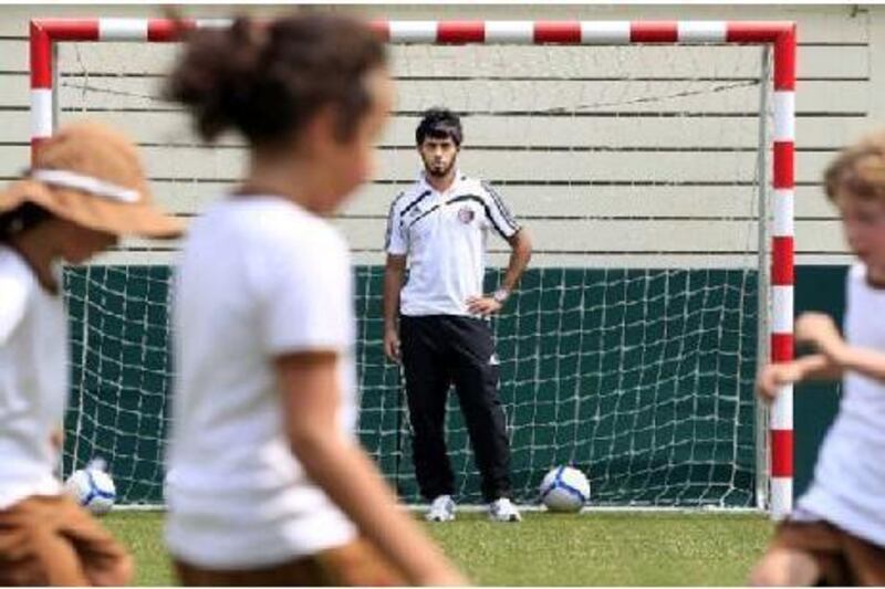 Al Jazira football player Sultan Barghash al Minhali works with children at Al Muna Primary School in Abu Dhabi.