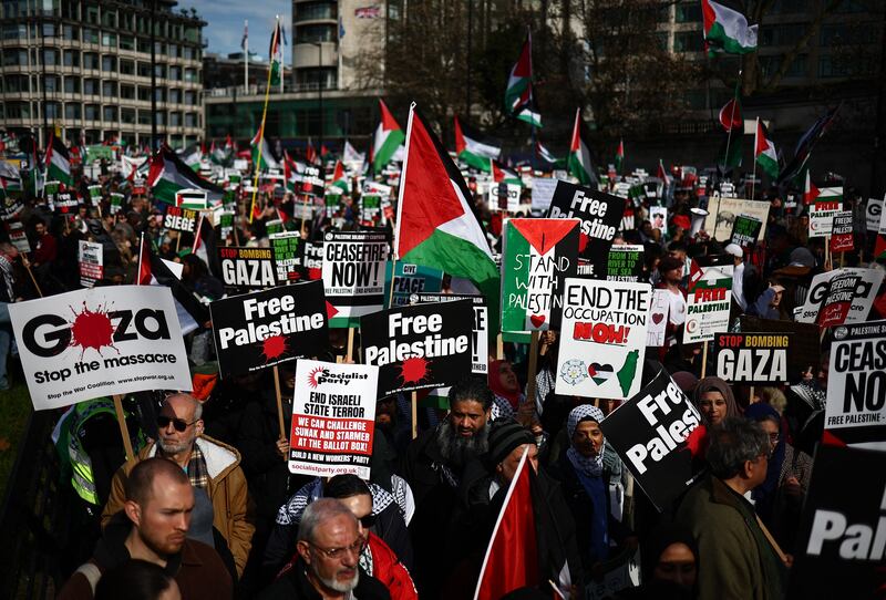 Pro-Palestinian activists and supporters wave flags and carry placards during a march through London, on Saturday. AFP