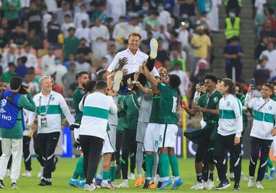 Herve Renard is thrown in the air by Saudi Arabia players after the team confirmed their qualification for the 2022 World Cup. AFP