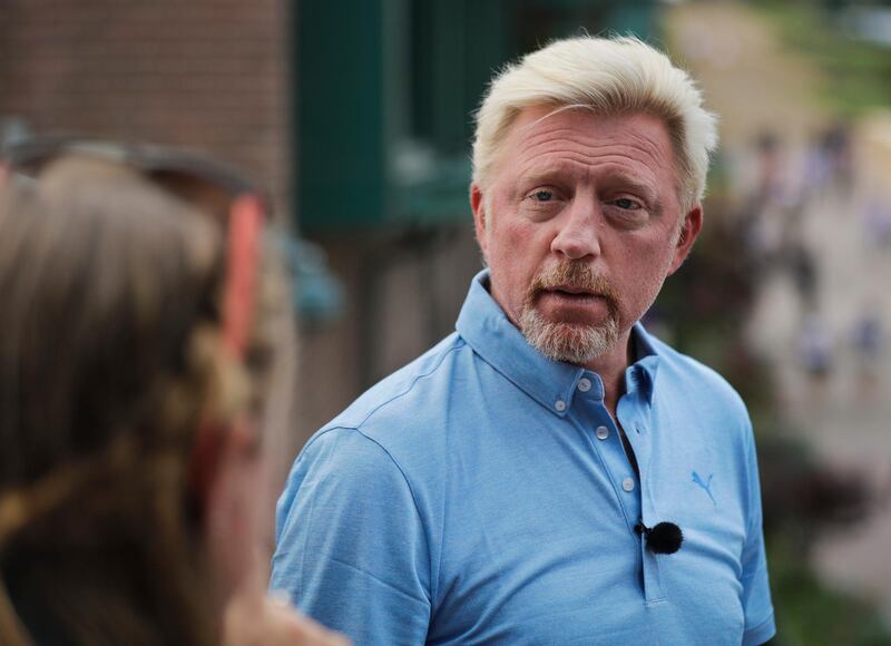 FILE - In this Sunday, July 1, 2018 file photo former tennis champion Boris Becker listens to a member of the camera crew as he interviews Novak Djokovic of Serbia, ahead of the start of the Wimbledon Tennis Championships in London. Retired German tennis star Boris Becker has dropped his claim to have diplomatic immunity from bankruptcy proceedings in Britain. The three-time Wimbledon champion had been claiming that his unpaid role as a sports attache for Central African Republic gave him immunity from bankruptcy rulings.(AP Photo/Ben Curtis, File)