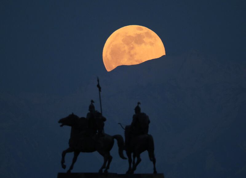 The Flower Moon looms over the Ile Alatau mountains and a monument to Kazakh folk heroes and warriors Suranshi and Sauryk in the village of Uzunagach, Almaty, Kazakhstan, on May 5. Reuters