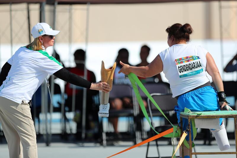 An organiser helps Mongolia's  Tsogtgerel Gendendarjaa in the woman's Shot Put F57. EPA