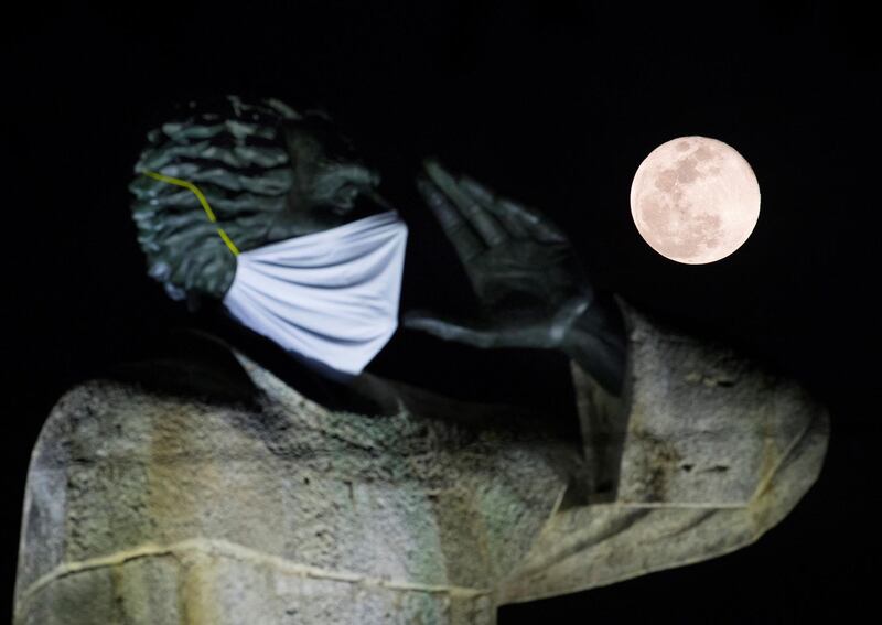 A full Moon rises behind the statue of priest Antonio Montesino wearing a face mask in Santo Domingo, Dominican Republic. EPA
