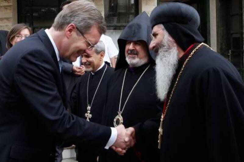 German President Christian Wulff (L) is welcomed by Bishop Grigorios Melki Urek of Adiyaman (R) and the other priests as he arrives for an ecumenical service at the church for St. Paul in Tarsus, southern Turkey, October 21, 2010. REUTERS/Umit Bektas(TURKEY - Tags: POLITICS RELIGION)