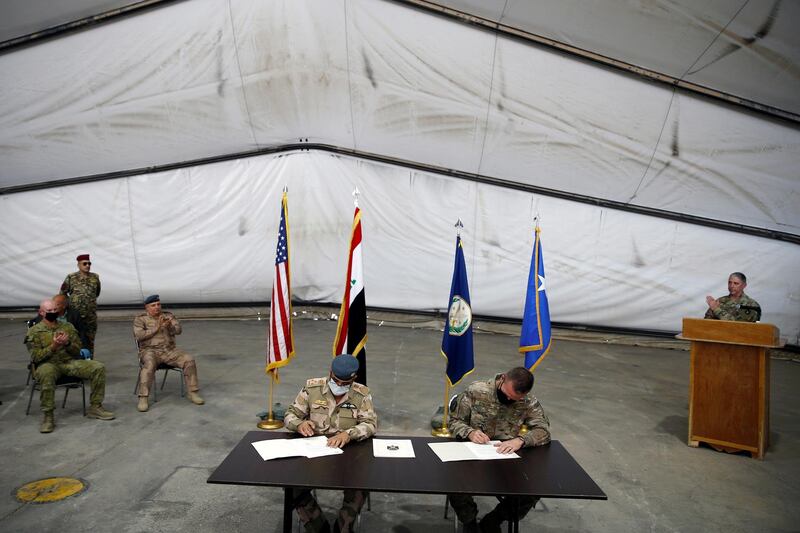 Maj. Gen. Kenneth P. Ekman, Deputy Commander of Combined Joint Task Force-Operation Inherent Resolve, signs documents with Brigadier General Salah Abdullah during a handover ceremony of Taji military base from US-led coalition troops to Iraqi security forces, in the base north of Baghdad, Iraq August 23, 2020. REUTERS/Thaier Al-Sudani