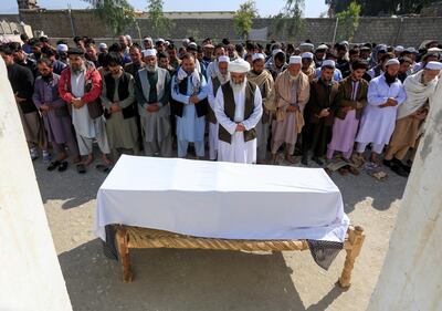 FILE PHOTO: Afghan men pray in front of the coffin of one of three female media workers who were shot and killed by unknown gunmen, in Jalalabad, Afghanistan March 3, 2021. REUTERS/Parwiz/File Photo
