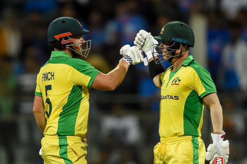 Australia's Aaron Finch (L) and teammate David Warner (R) celebrate after each scored a century (100 runs) during the first one day international (ODI) cricket match of a three-match series between India and Australia at the Wankhede Stadium in Mumbai on January 14, 2020. IMAGE RESTRICTED TO EDITORIAL USE - STRICTLY NO COMMERCIAL USE
 / AFP / Punit PARANJPE                       / IMAGE RESTRICTED TO EDITORIAL USE - STRICTLY NO COMMERCIAL USE
