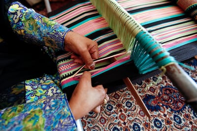 Madinat Zayed, January 21, 2013 --  Hamda Almazrouei, 46, uses a floor loom to weave a table runner  at her mother's home in Madinat Zayed, January 21, 2013. (Photo by: Sarah Dea/The National)