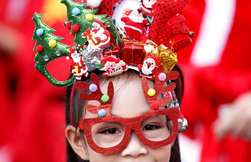 A student waits as she take part in a visit with a troupe of elephants (unseen) to distribute Christmas presents to students in a school at the historical city of Ayutthaya, Thailand. REUTERS