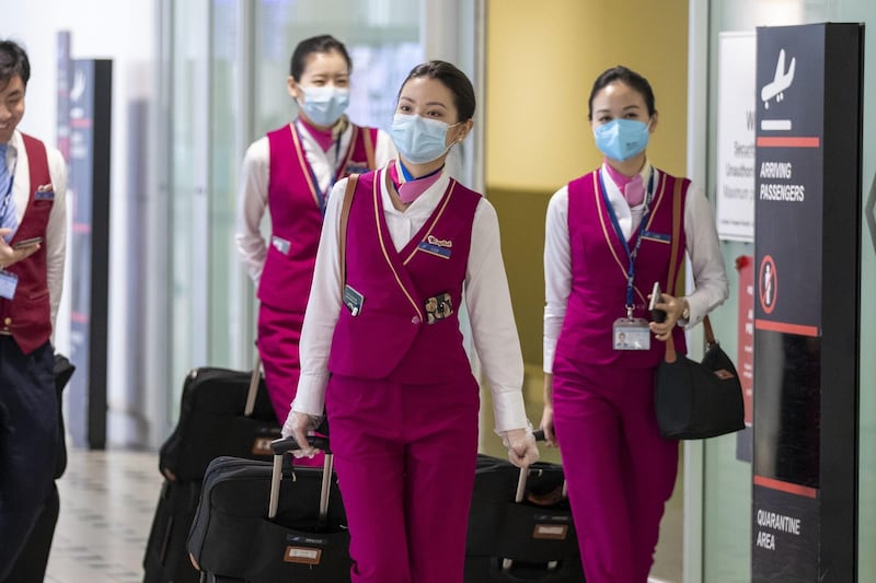 Flight attendants wear protective face masks at Brisbane International Airport in Brisbane.  EPA