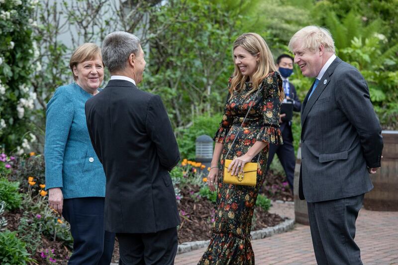 Britain's Prime Minister Boris Johnson his wife Carrie Johnson share a joke with German Chancellor Angela Merkel and her husband Joachim Sauer during a reception for the G7 leaders at the Eden Project in Cornwall. AP