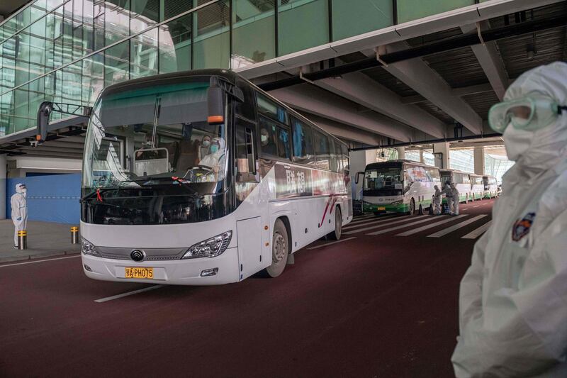 A bus carrying members of the WHO team investigating the origins of the Covid-19 pandemic leaves the airport following their arrival at a cordoned-off section in the international arrivals area at the airport in Wuhan. AFP