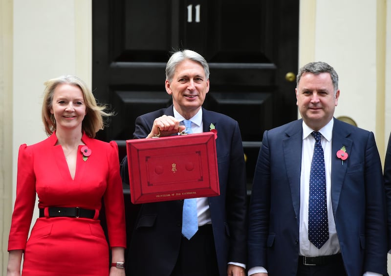 Former Chancellor Philip Hammond, centre, holding his red ministerial box outside 11, Downing Street, flanked by Treasury colleagues Ms Truss and Mel Stride in October 2018.  PA