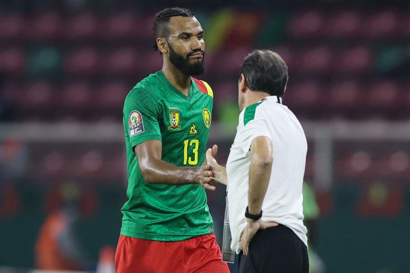 Cameroon forward Eric Choupo Moting shakes hands with coach Antonio Conceicao after being substituted. AFP