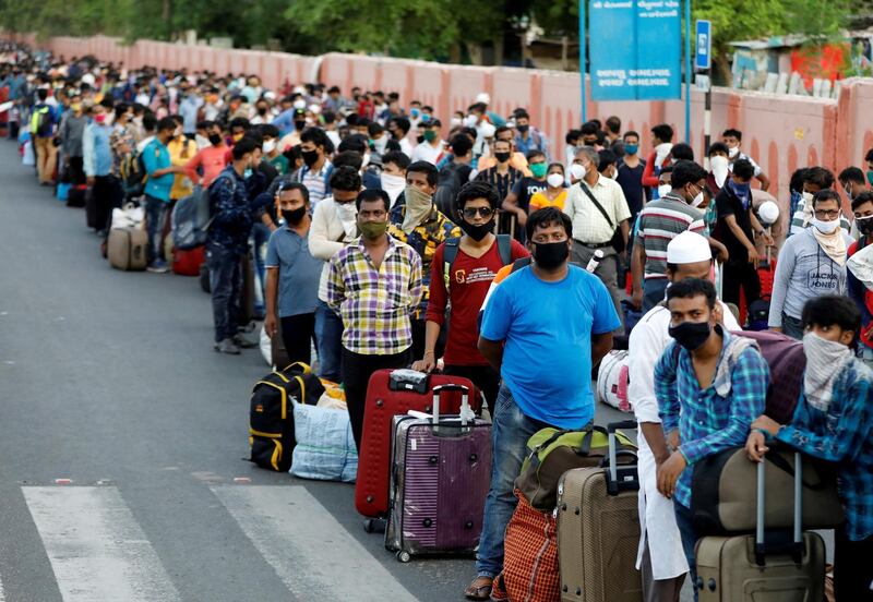 Migrant workers and their families wait in lines outside a railway station in Ahmedabad, India. Reuters