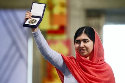 Nobel Peace Prize laureate Malala Yousafzai displays her medal during the Nobel Peace Prize awards ceremony at the City Hall in Oslo, Norway, on December 10, 2014. 17-year-old Pakistani girls' education activist Malala Yousafzai known as Malala shares the 2014 peace prize with the Indian campaigner Kailash Satyarthi, 60, who has fought for 35 years to free thousands of children from virtual slave labour.      AFP PHOTO /POOL/CORNELIUS POPPE / AFP PHOTO / POOL / CORNELIUS POPPE