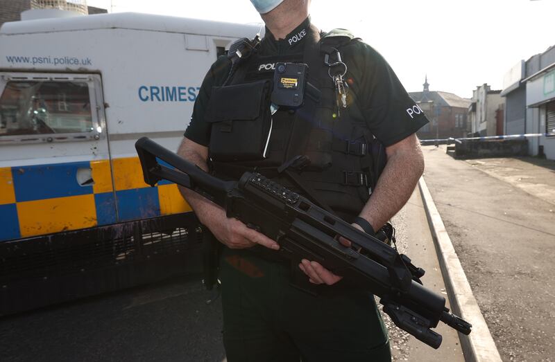 An armed officer holds a submachine gun at a police cordon in Belfast, 2022. Police in Northern Ireland carry guns and wear body armour while on patrol, unlike their counterparts in Great Britain or in the Republic of Ireland. PA