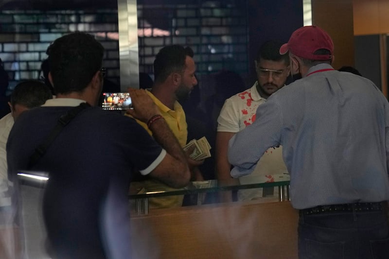An armed woman and a dozen activists reportedly broke into a Beirut bank branch to retrieve more than $13,000 from what she said were her trapped savings. Lebanon's cash-strapped banks since 2019 have imposed strict limits on withdrawals of foreign currency, tying up the savings of millions. AP Photo