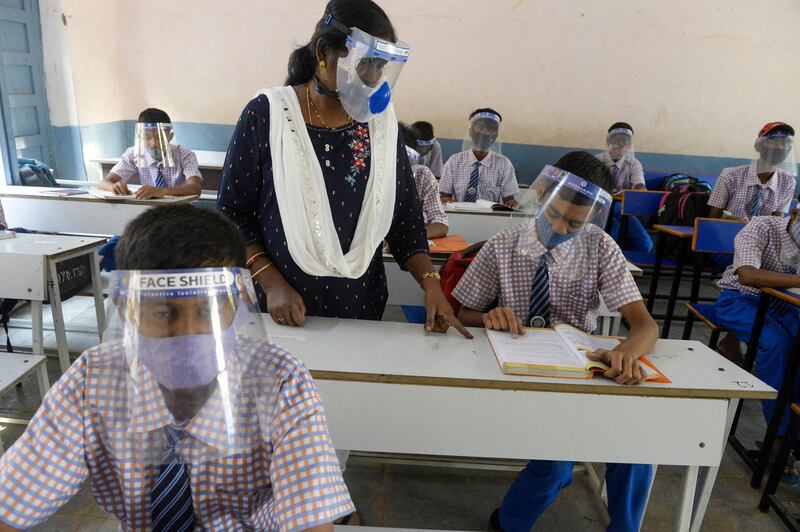 Students wearing facemasks and face-shields attend a class after their school reopened for the 9th and 10th grades following nearly ten months closure due to the Covid-19 coronavirus pandemic in Hyderabad on February 6, 2021. (Photo by Noah SEELAM / AFP)