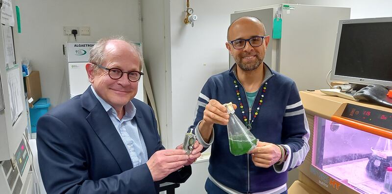 Professor Christopher Howe and Dr Paolo Bombelli with their algae device and a flask of algae. Photo: Paolo Bombelli